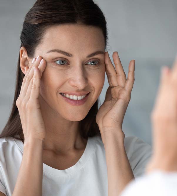 Woman looking in the mirror deciding if she should get Botox injections