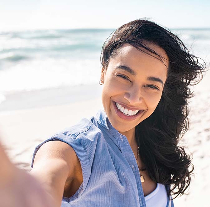Woman taking a selfie in the sun on a beach