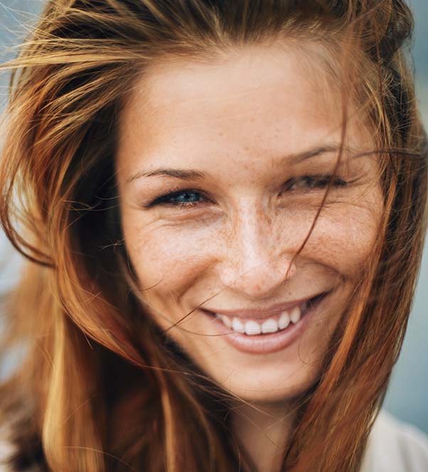 Red headed woman close up showing clear skin
