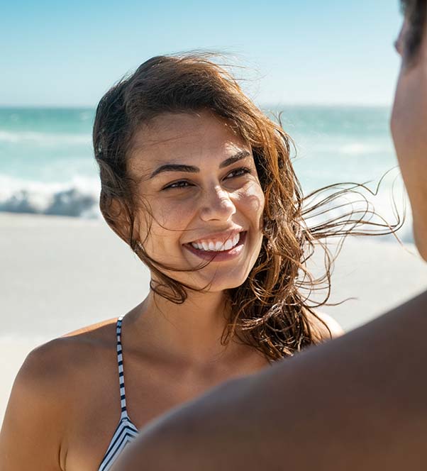 A beautiful woman on the beach talking to a man